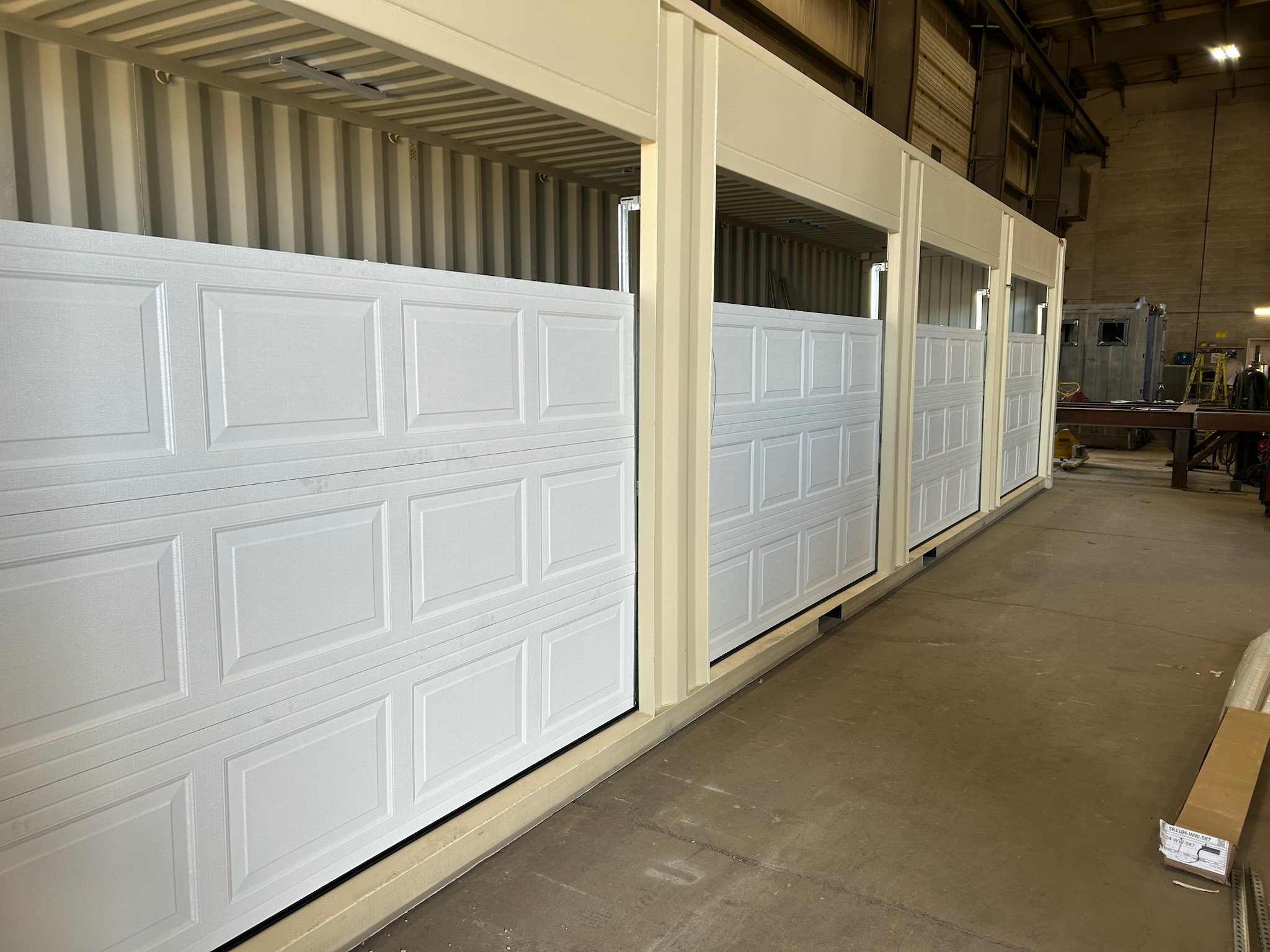White commercial overhead doors inside a workshop